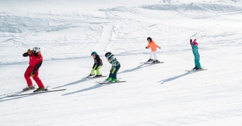 Skilehrer der Skischule Obergurgl führt vier Kinder über eine flache Piste