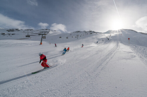 Skiers on a wide, sunny slope in the Obergurgl-Hochgurgl ski area